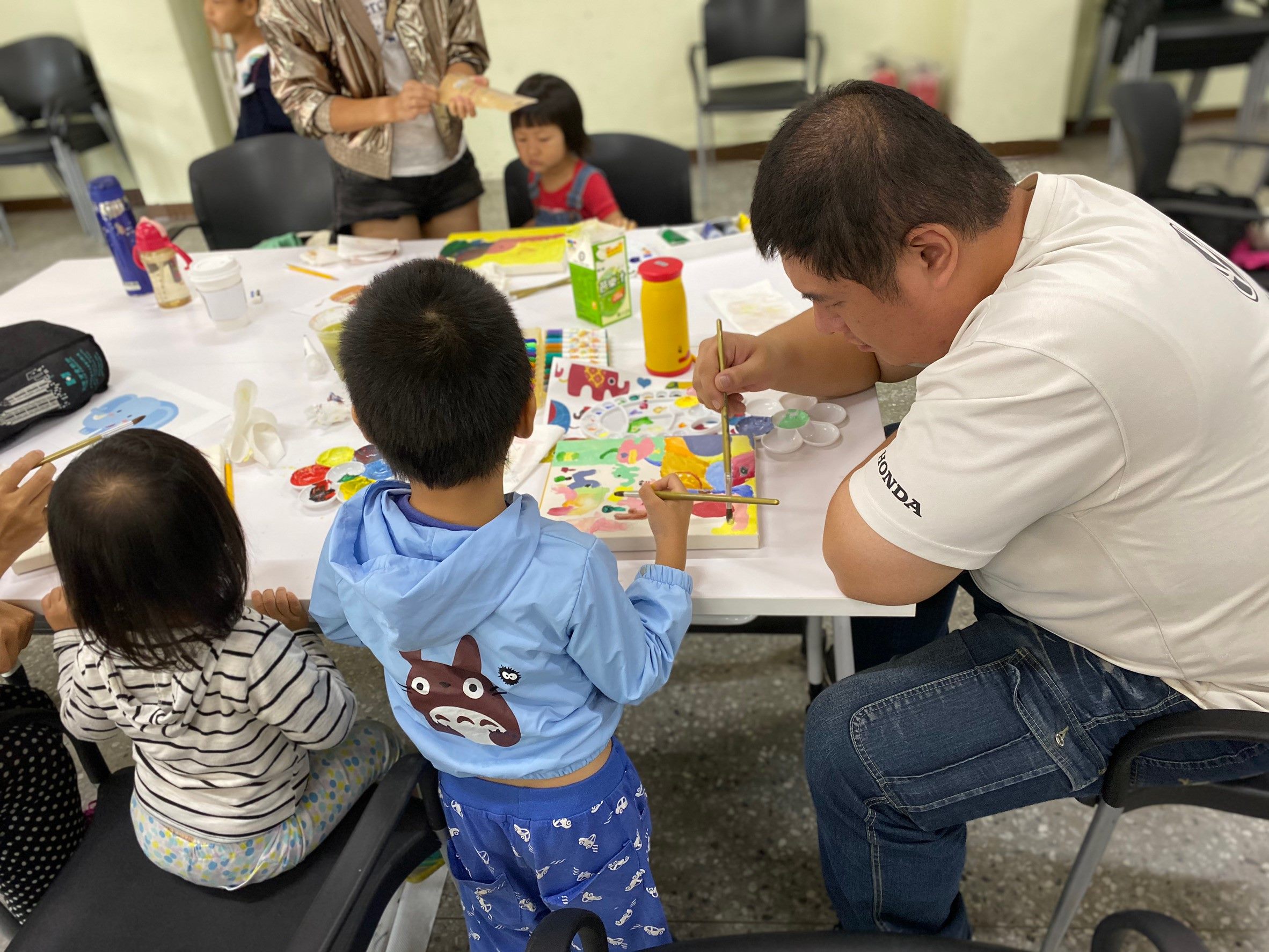 Parents and children painting a Thai elephant together