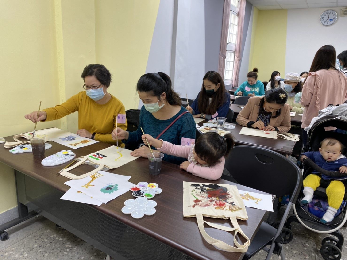 New immigrant families painting clothe bags