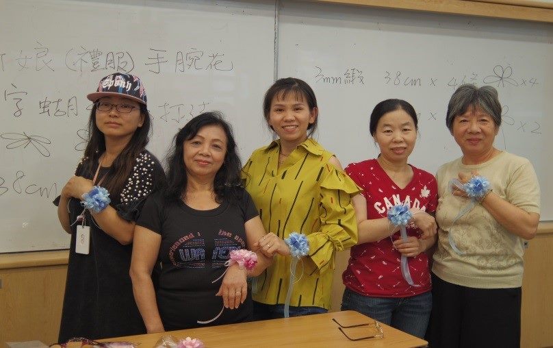 Student showcasing handmade wrist corsages 