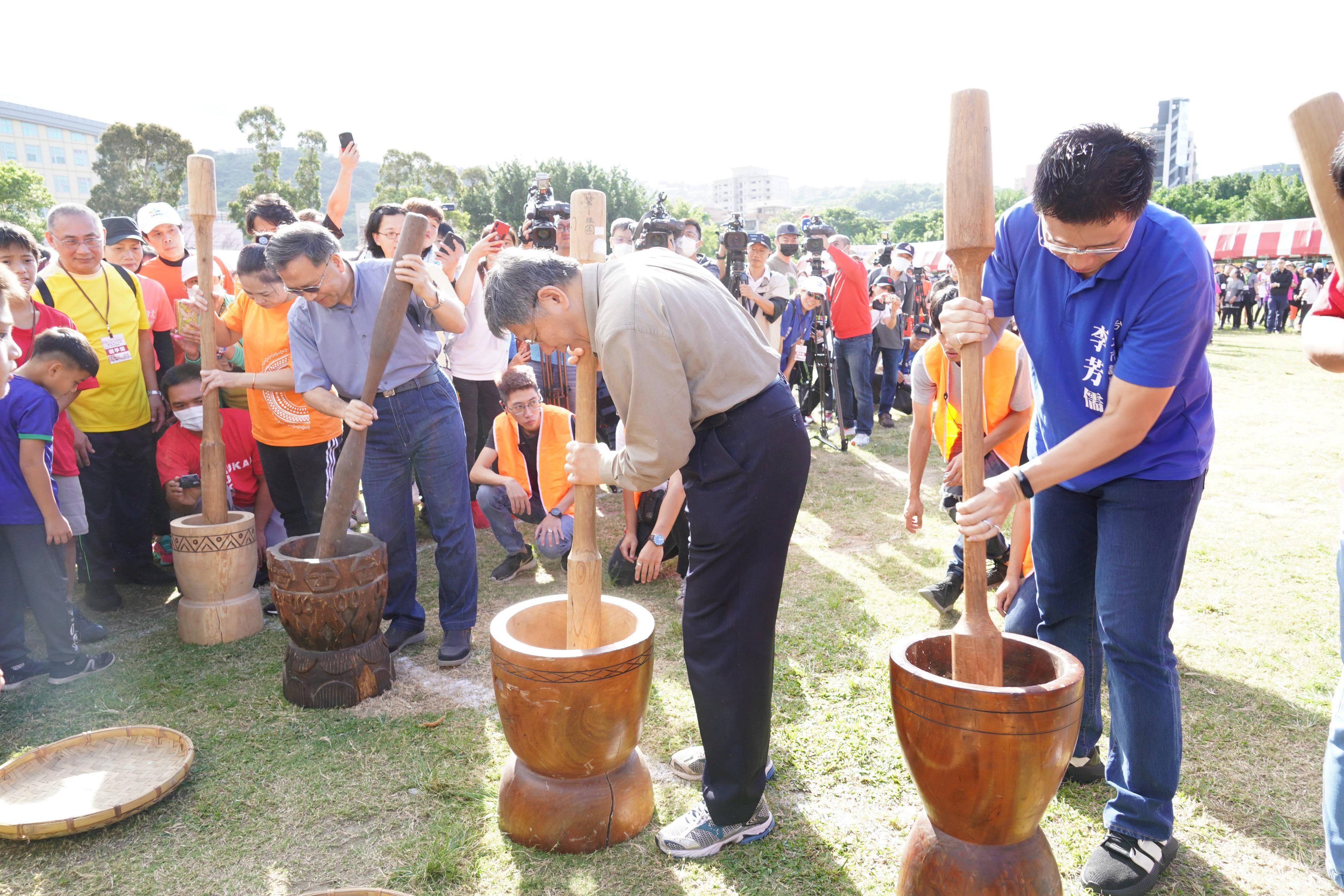 Mayor pounding on millet mochi with other participants