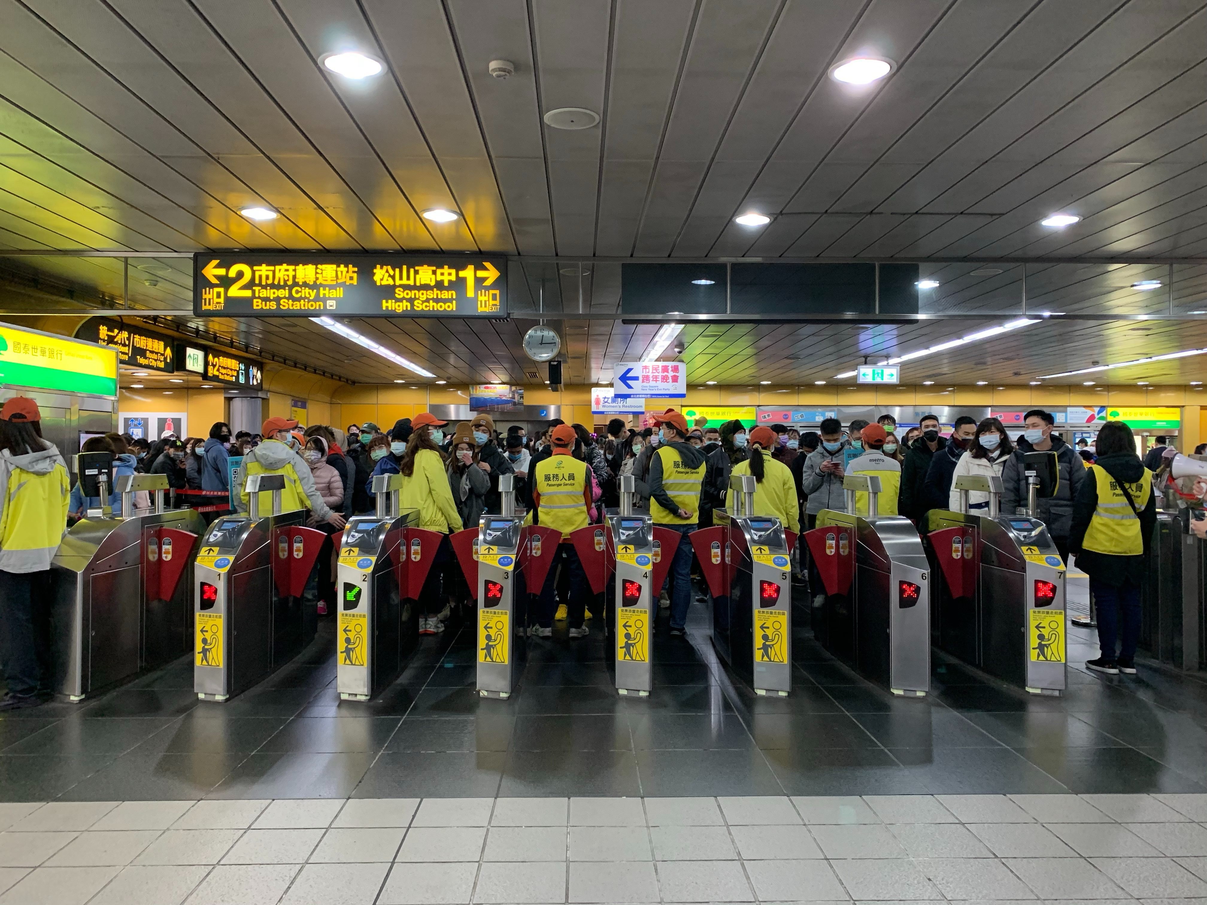 Passengers line up outside the gates at the MRT Station