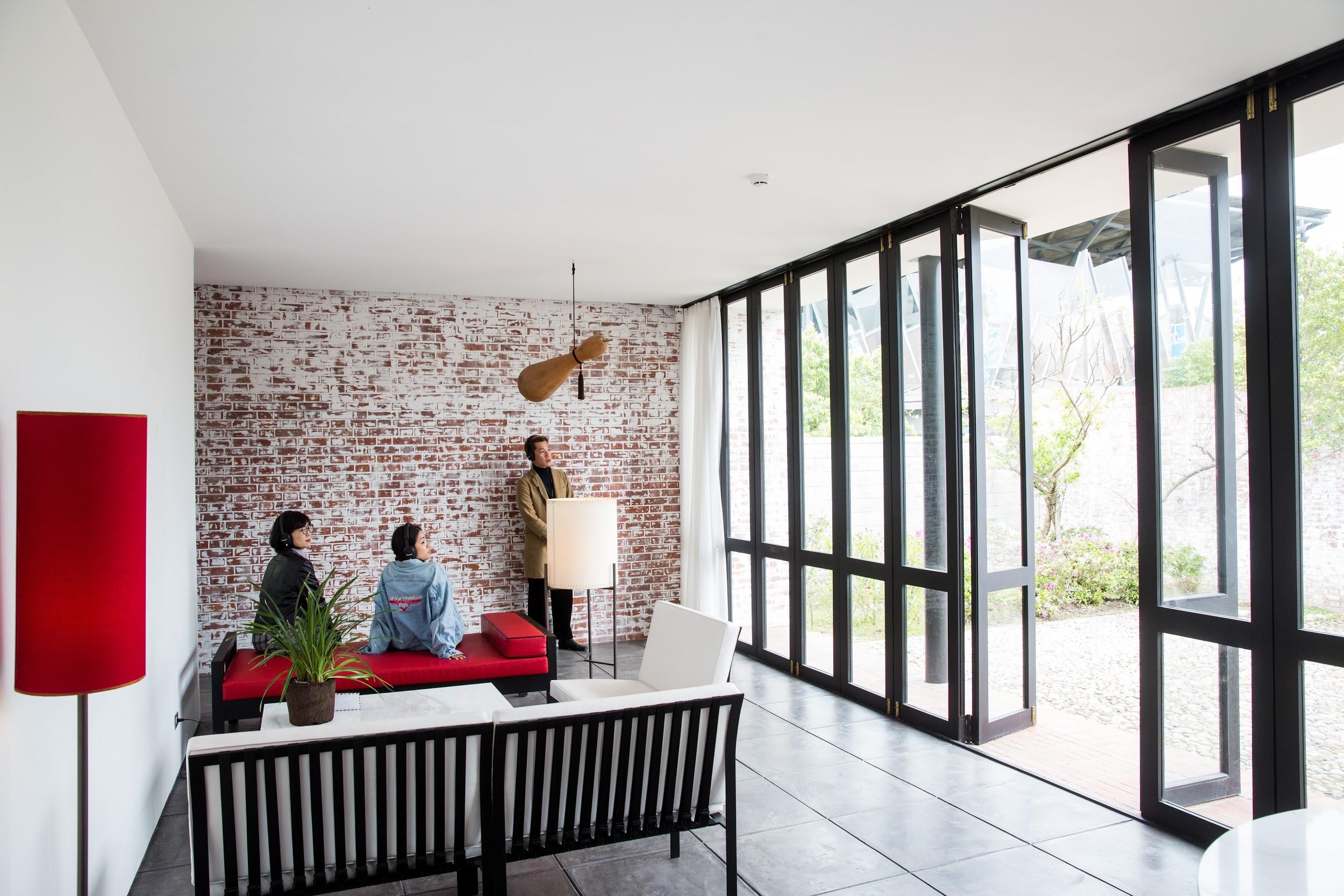 The modernist house features a red, black, and white color scheme and plain brick walls in demonstration of Wang Da Hong’s aesthetic. 