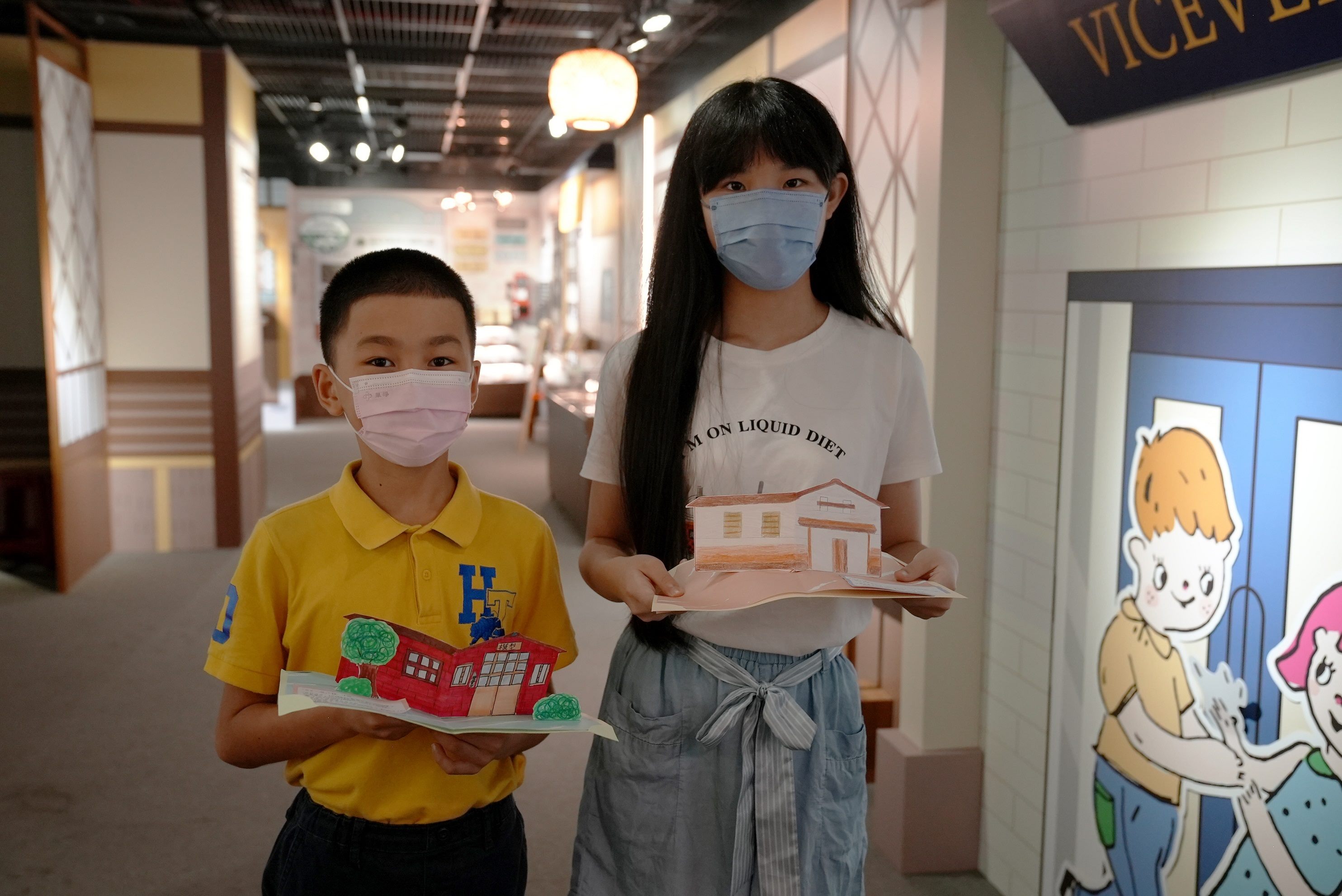 西松國小六年級賴妤蓁和東園國小五年級高唯恪展示立體老房子卡片
