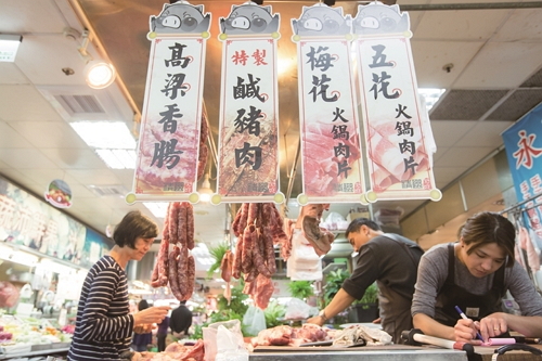 fresh pork meat hanging in a butcher's stall