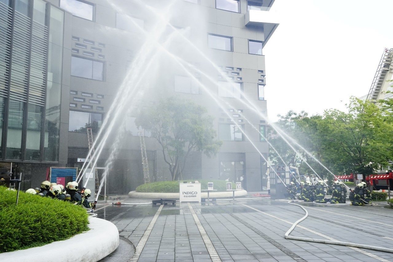 Firefighters spraying water at a building during the drill